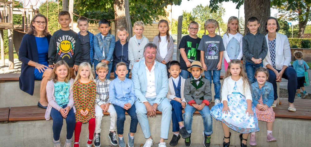 18 Kinder der 1a (mit Direktorin Gabriele Weiler (links) und Bgm. Ing. Martin Falk sowie Klassenlehrerin
                                    Isabella Stocklasser) sind am 4. September in ihr erstes Schuljahr gestartet. 