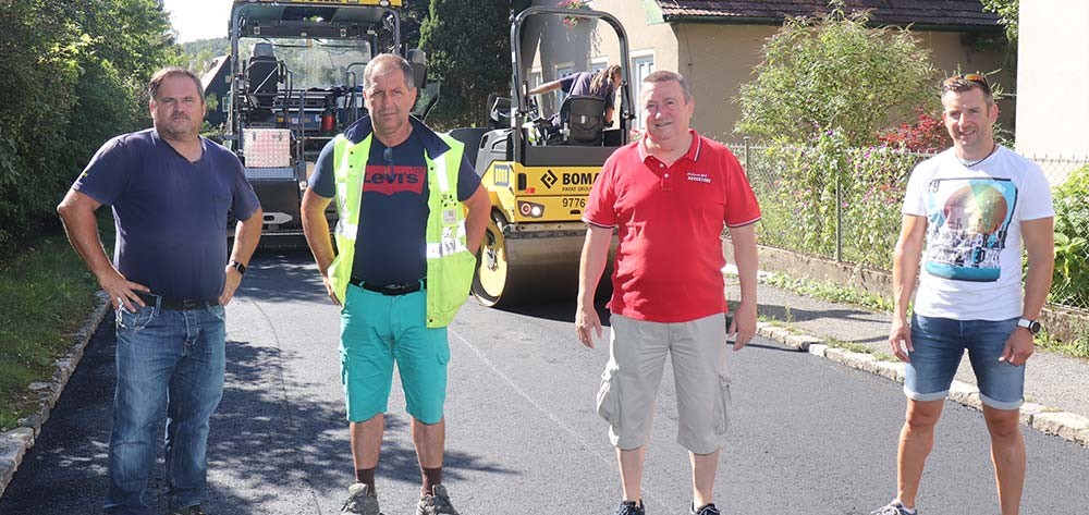 von rechts nach links: Porr-Bauleiter Philipp Wohlgemuth, Straßenbaureferent GGR Dipl.(HTL)Ing. Alfred Gundinger mit
                                    (den beiden Polieren Catalin Sievers und Alija Strugalioski prüfen den neuen Asphaltbelag in der Webergasse.